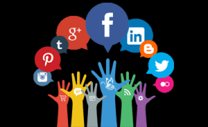 Amidst the dark void, like a phoenix rising from ashes, colorful silhouetted hands reach upwards, each alight with the vibrant flames of social connection; adorned with speech bubbles bearing icons of Facebook, Twitter, Instagram, and LinkedIn—a fiery muse for innovative WordPress web design projects.